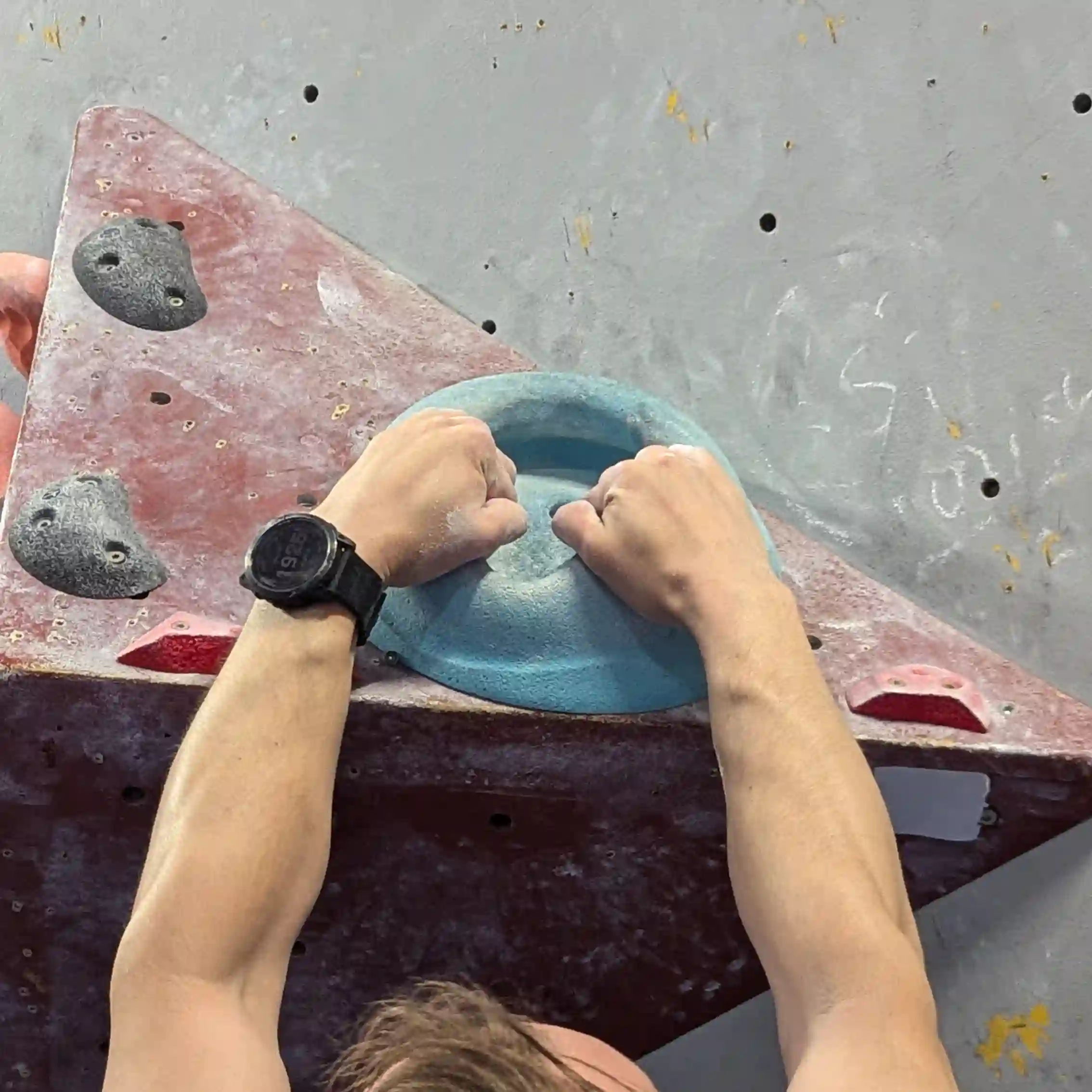 Shows the climber gripping the hold. Imagine trying to pry open an elevator door - this is the position of the hands.