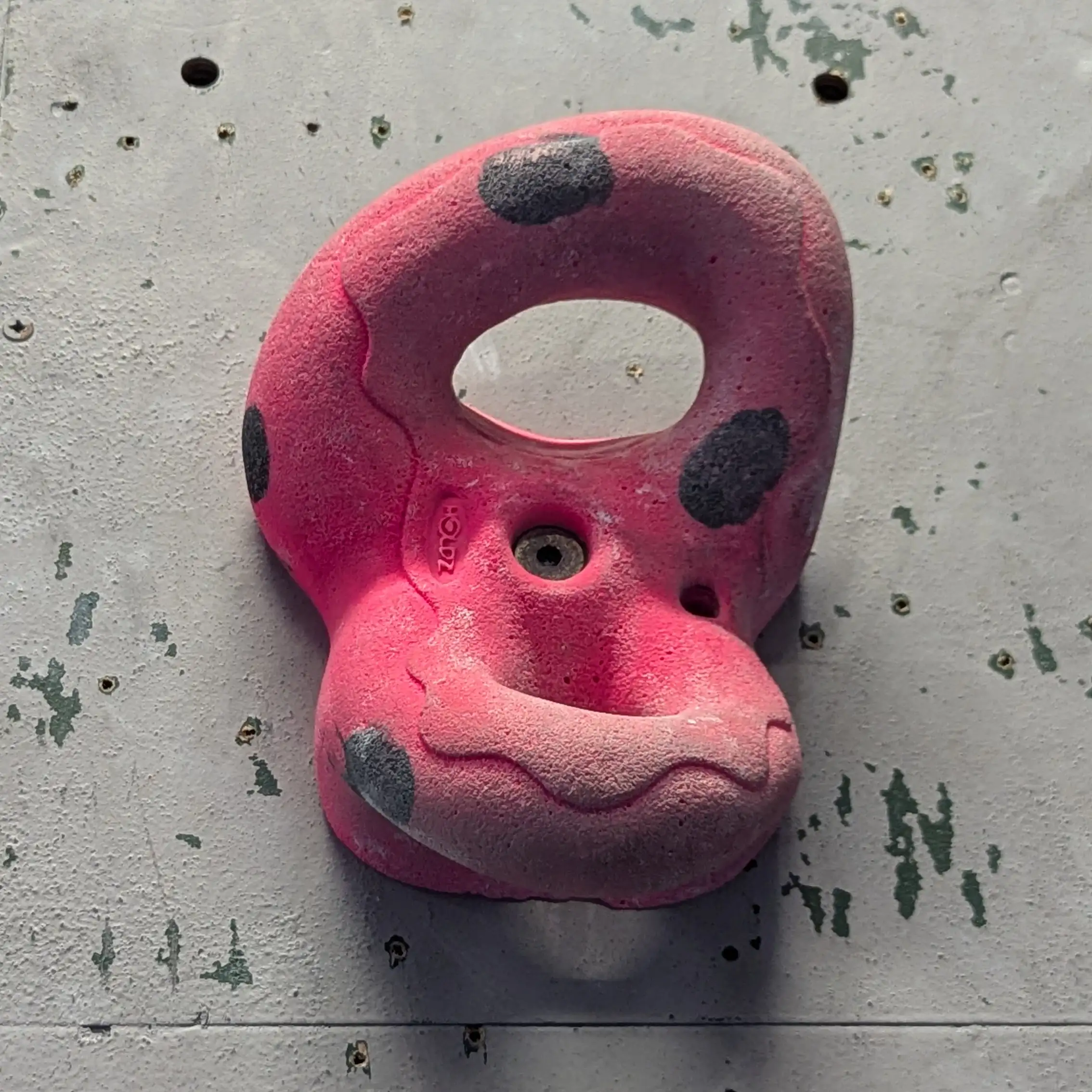 A pink jug hold that looks like a figure of eight. It has two holes in it.