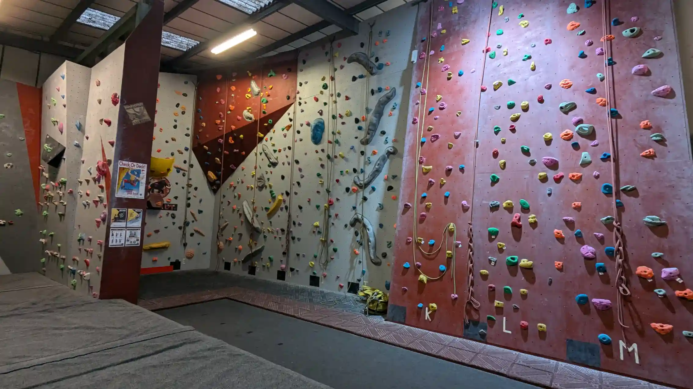 Shows the climber on the bouldering wall attempting to position his toe for the the toe hook.