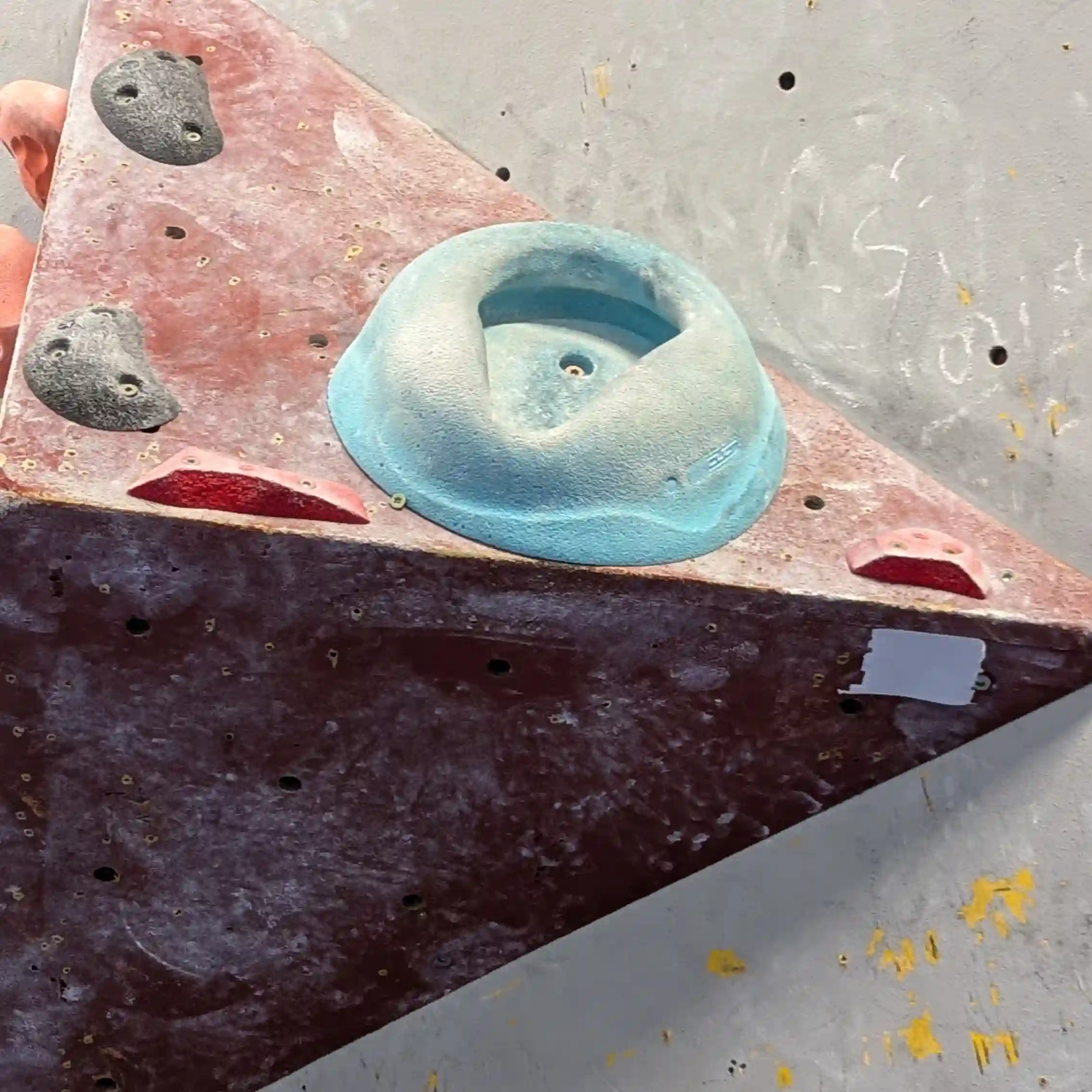 Shows the climber on the bouldering wall attempting to position his toe for the the toe hook.