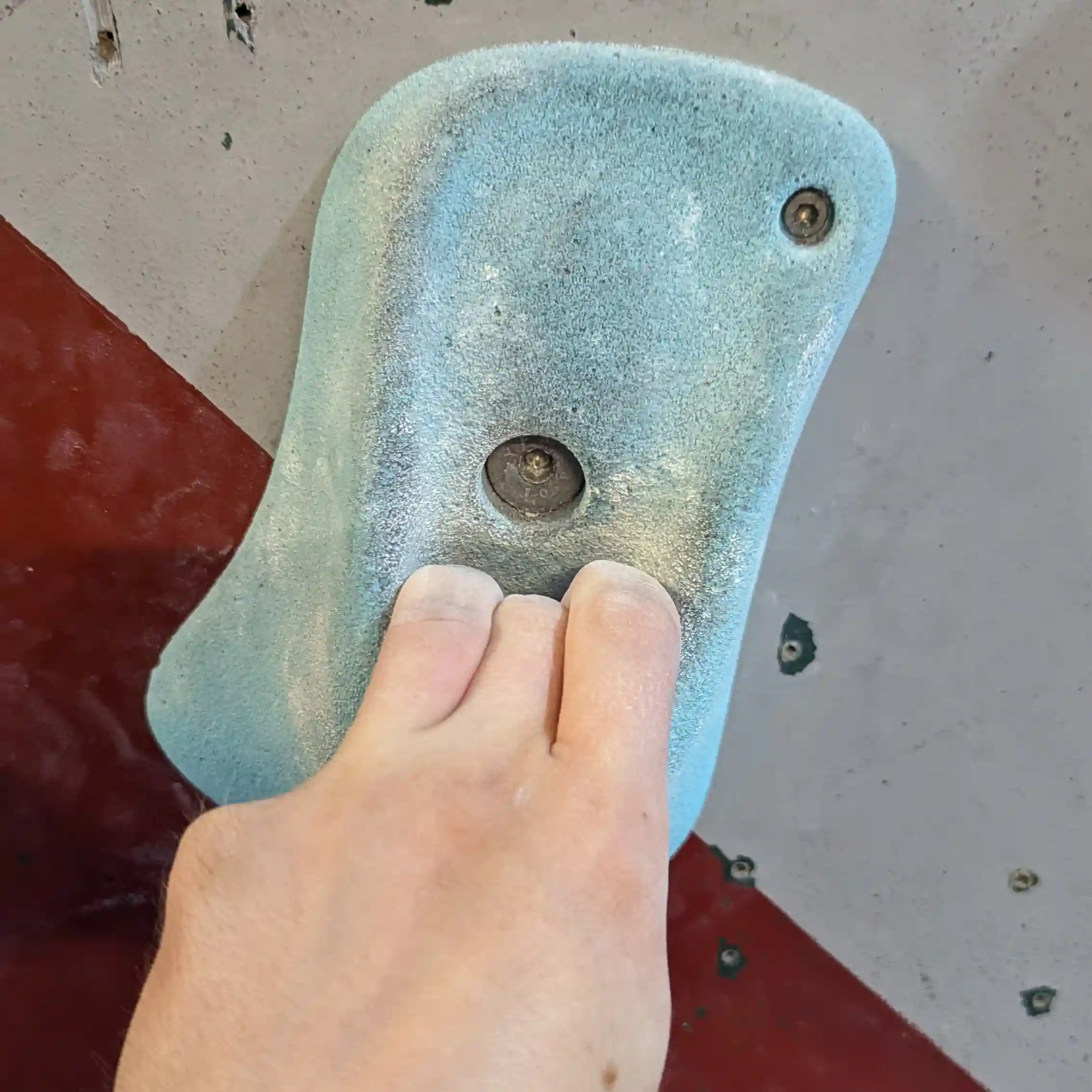 Shows the climber using only 3 fingers and not their thumb to hold the coat pocket looking hold.