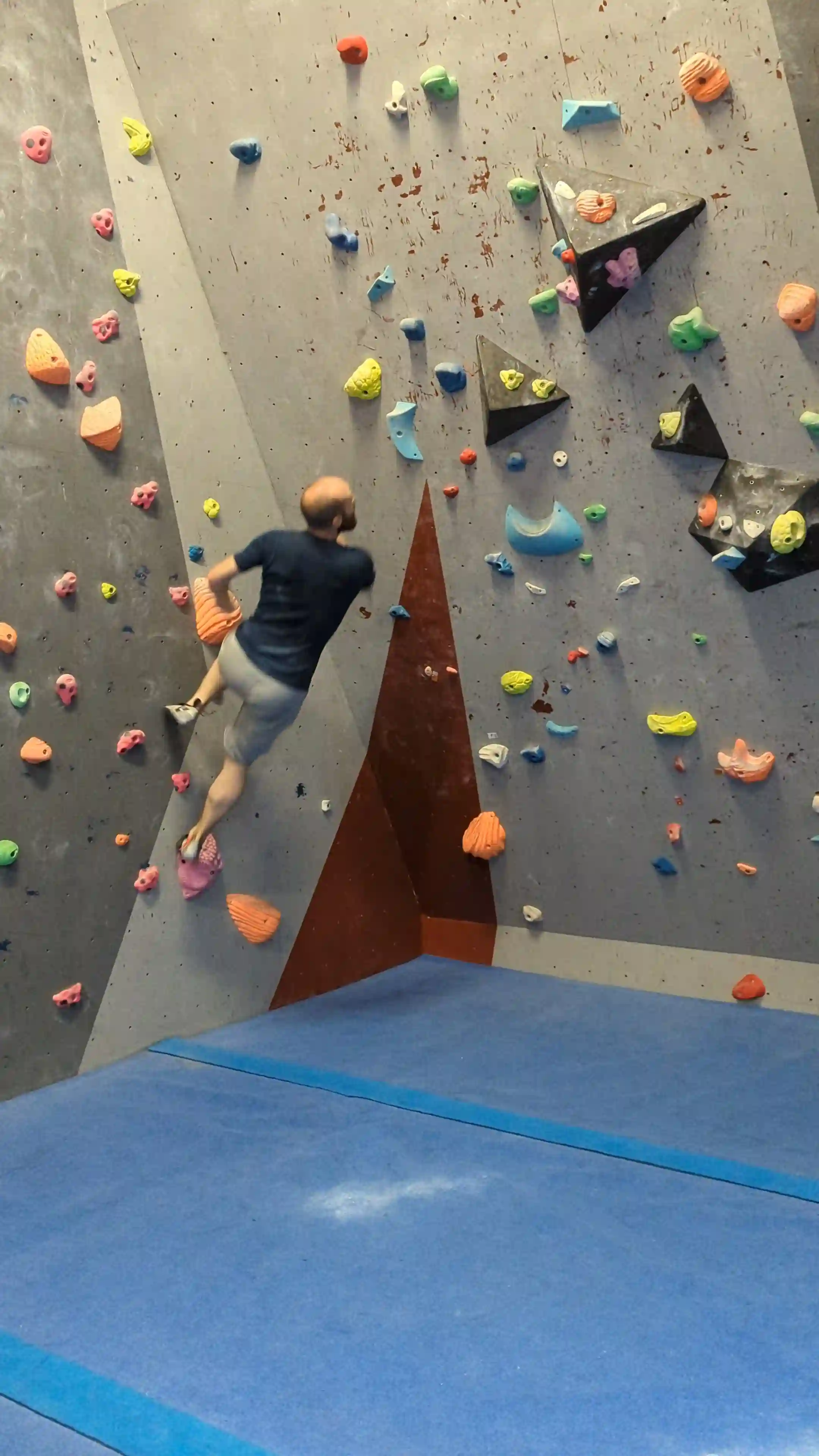 Shows the climber on the smearing up the wall with their feet to get into position ready to jumpp away from the wall.