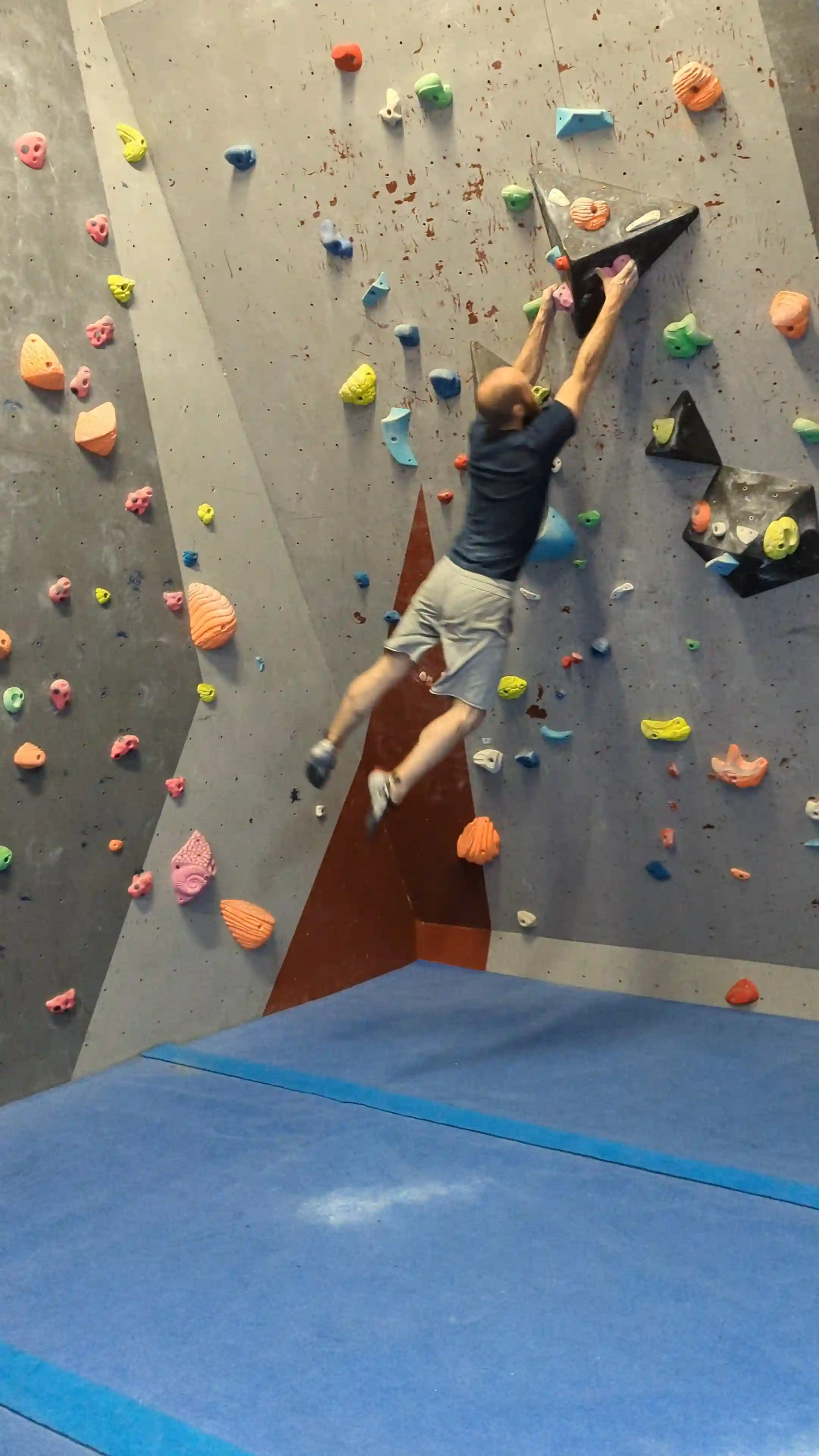 Shows the climber making contact with the hand holds and attempting to stick the hold.