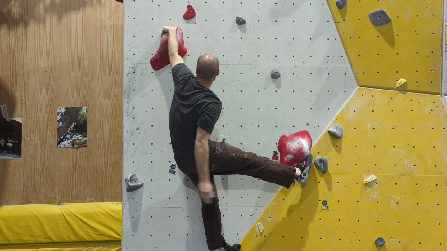 Shows the climber on the bouldering wall able to reposition themselves since the toe hook move is able to keep them stable on the wall.